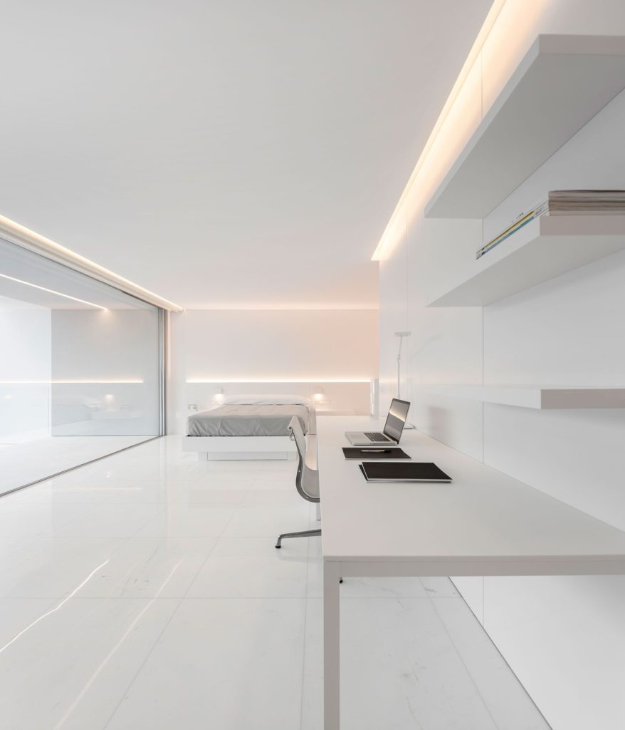 Habitación de estilo minimalista con estudio, con iluminación indirecta en el techo y el cabecero de la cama.